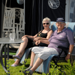 Camping-13 Seniorer nyder solskinnet foran fortelt på campingplads